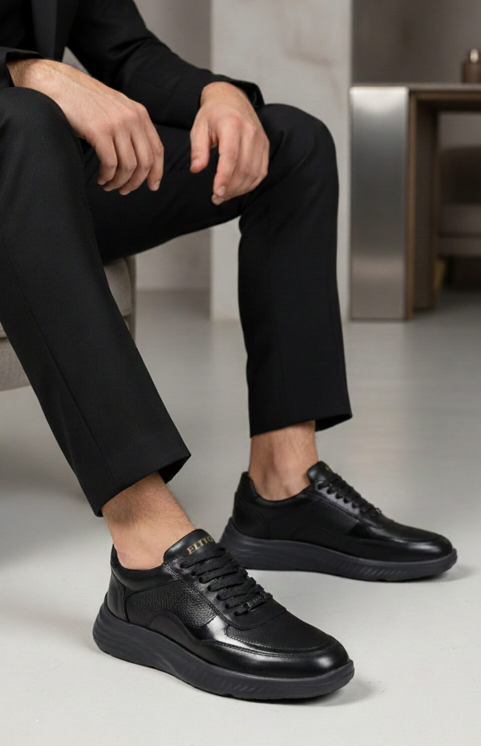 Détail cuir grainé et fiSneakers AXIS noir portées avec costume - Baskets élégantes en cuir noir brillant - Style moderne professionnel confortablenitions premium sneaker AXIS Elito